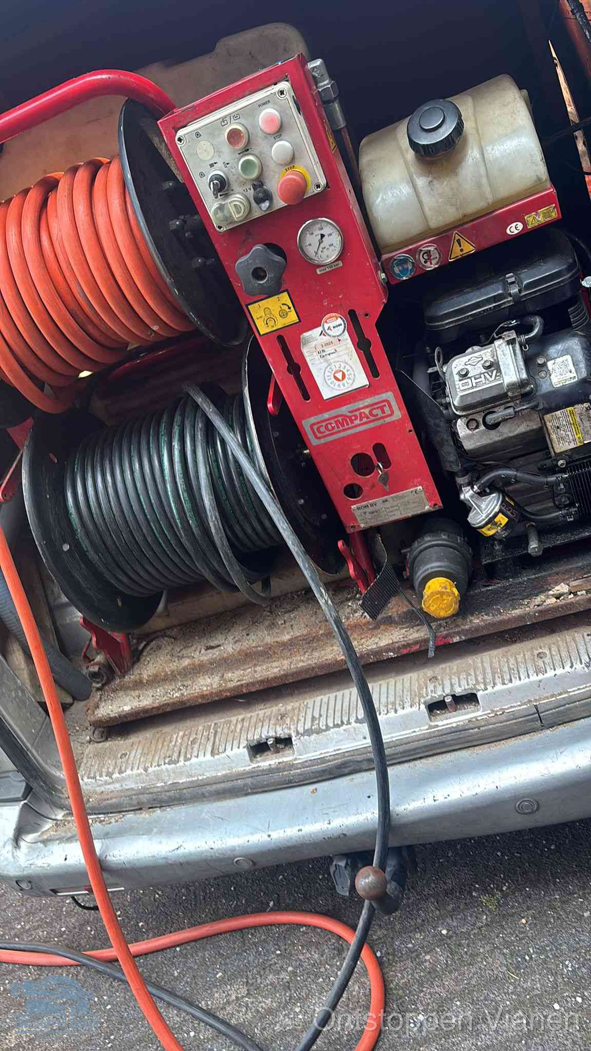Een rood hogedruk-rioolreinigingstoestel met slangen in de laadbak van de bedrijfsbus, apparatuur voor een hardnekkige wc-verstopping in Vianen