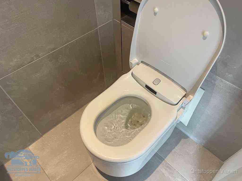 Een toiletpot vol troebel water met drijvend papier en restanten, de meest voorkomende oorzaak van een verstopte wc in Vianen