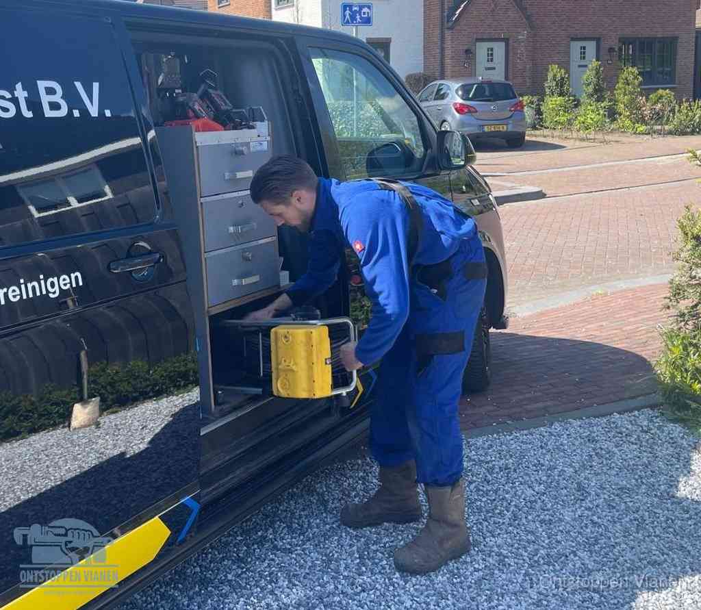 Een monteur pakt apparatuur uit de bedrijfsbus voor service aan huis, het moment om een professional in te schakelen voor een verstopte wc in Vianen