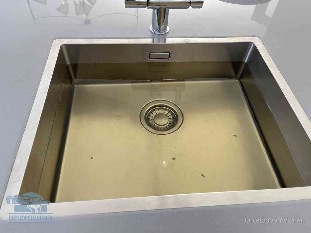 Stilstaand water in een rvs spoelbak dat niet wegloopt, een duidelijk signaal van een gootsteenverstopping in Vianen