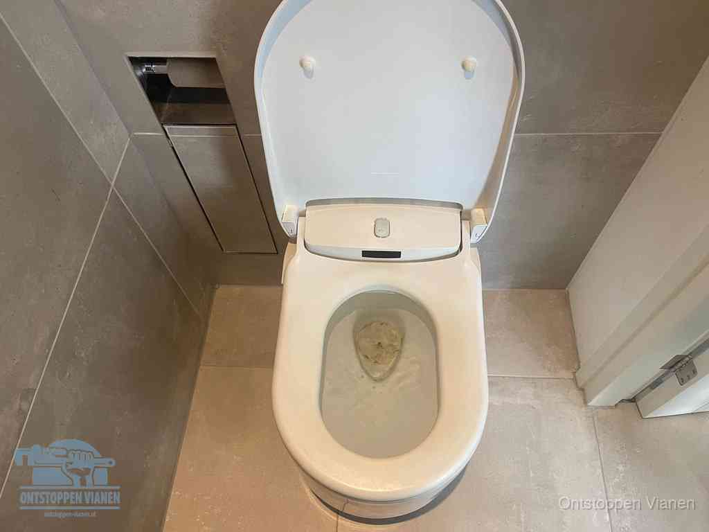 Een wit hangtoilet waarin een prop wc-papier op het water blijft drijven, een duidelijk signaal van een verstopte wc in Vianen
