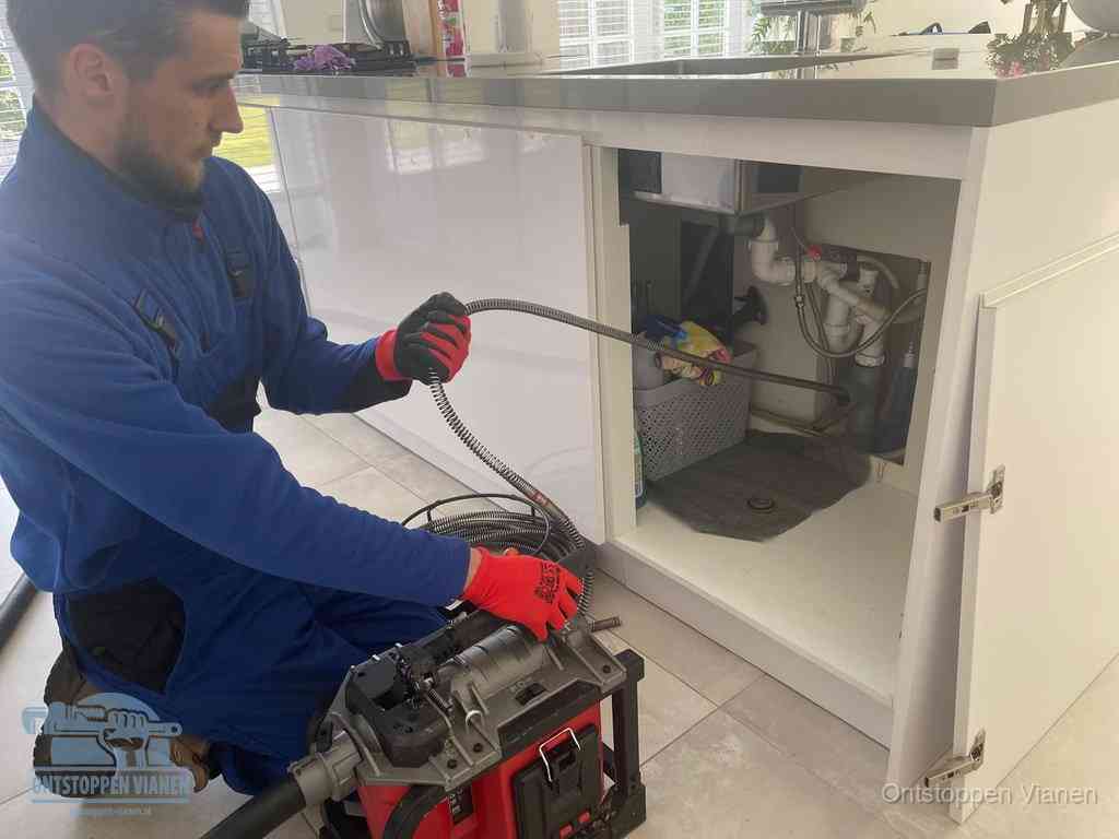 Een monteur reinigt de keukenafvoer grondig met een veermachine om terugkerende gootsteenverstoppingen te voorkomen in Vianen