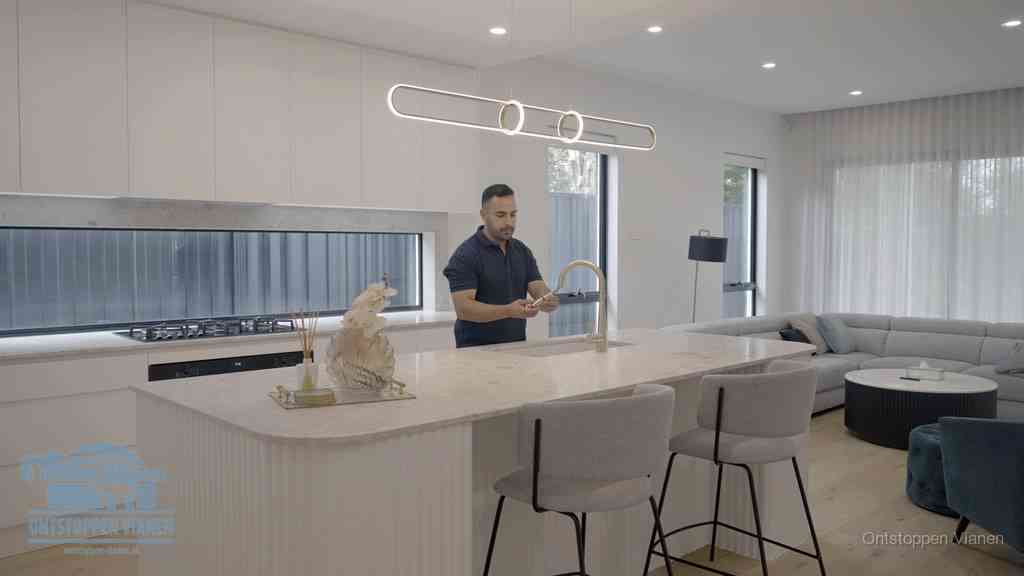 Een bewoner bij de keukenspoelbak die zelf aan de slag gaat met een verstopte gootsteen in Vianen